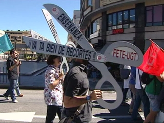 Manifestante portando una tijera reivindicativa de los recortes en el sector