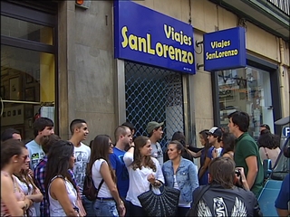Universitarios frente a las puertas de la agencia de Viajes San Lorenzo SL en Gijón