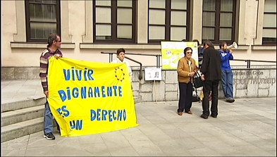 Varias personas protestando frente al edificio de Servicios Sociales de Gijón