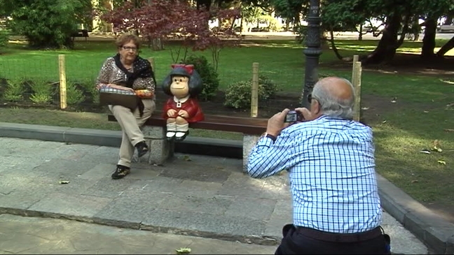 Unos visitantes haciéndose una foto con la escultura de Mafalda