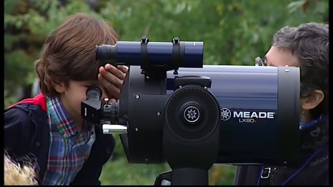 Un niño mira por un telescopio