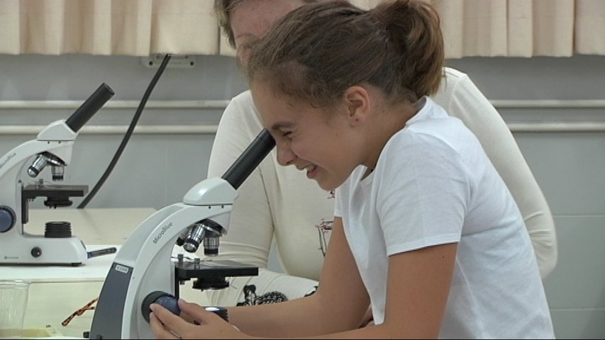 Semana de la Ciencia en Oviedo/ Una niña mirando por un microscopio en laboratorio