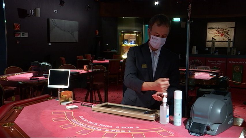Un empleado con mascarilla en una mesa de juego en el Casino de Gijón