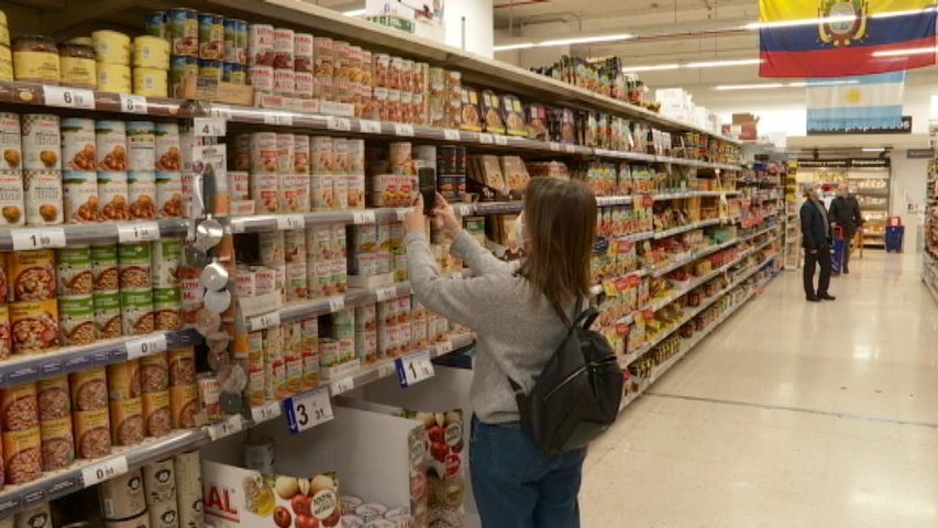 Un consumidor escaneando códigos de comida en un súper para ver si son saludables