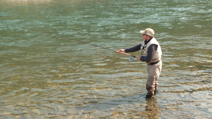 Un pescador pescando salmón en un río asturiano